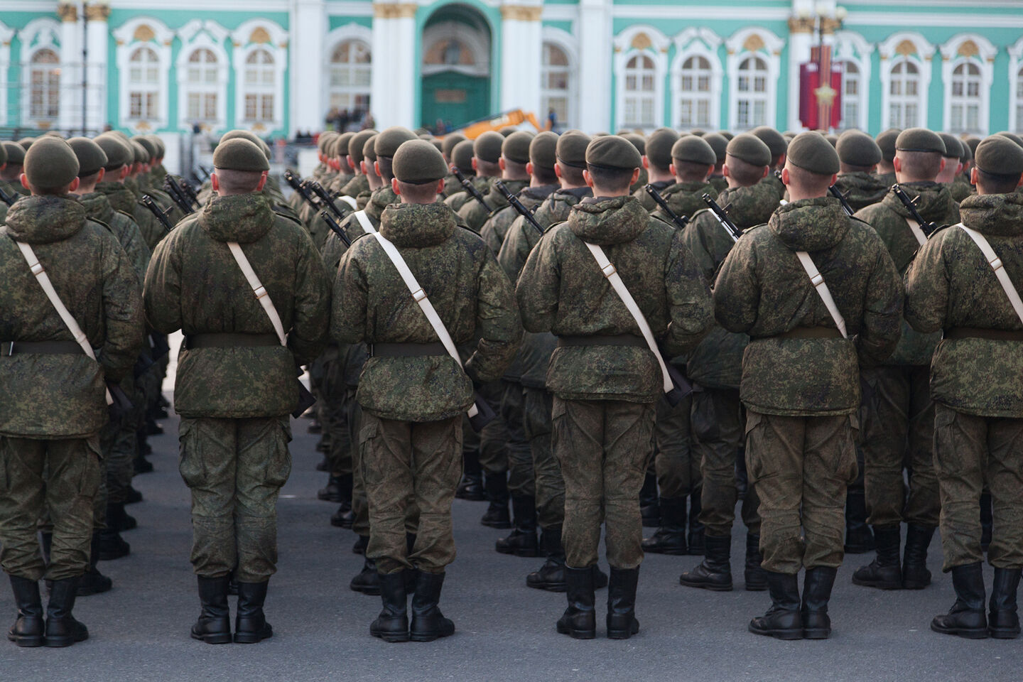 Russian soldiers in uniforms and military gear stand in formation on Palace Square in St. Petersburg.